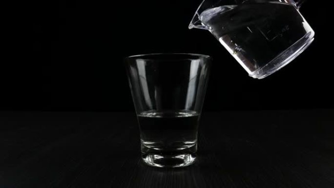 在黑色背景上的玻璃杯中混合异丙醇和水