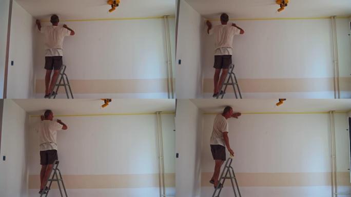 梯子上的画家，用胶带在墙壁上做边框，这样油漆就不会转移到天花板上