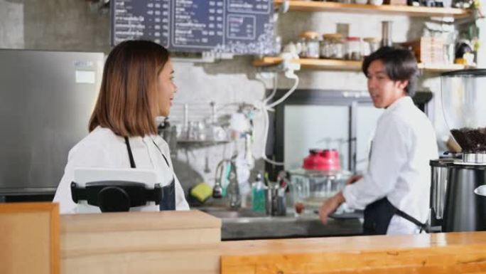 幸福的亚洲夫妇是一家小企业的老板，在咖啡店用平板电脑检查每日利润后，他们兴奋不已。