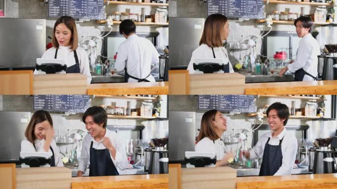 幸福的亚洲夫妇是一家小企业的老板，在咖啡店用平板电脑检查每日利润后，他们兴奋不已。
