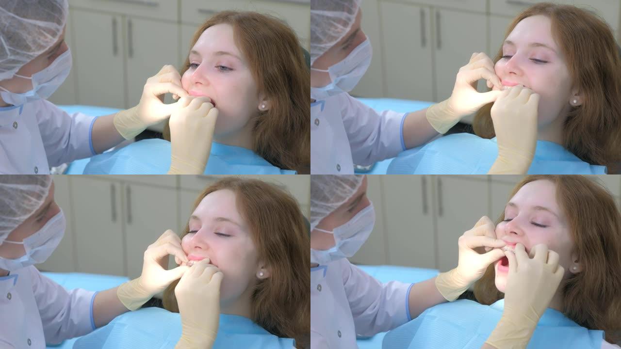 正畸医生将硅胶隐形透明牙套放在女孩的牙齿上。
