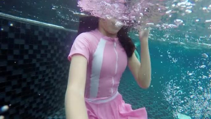 亚洲女孩戴着护目镜，在度假期间和家人一起在酒店潜水，生活方式理念。