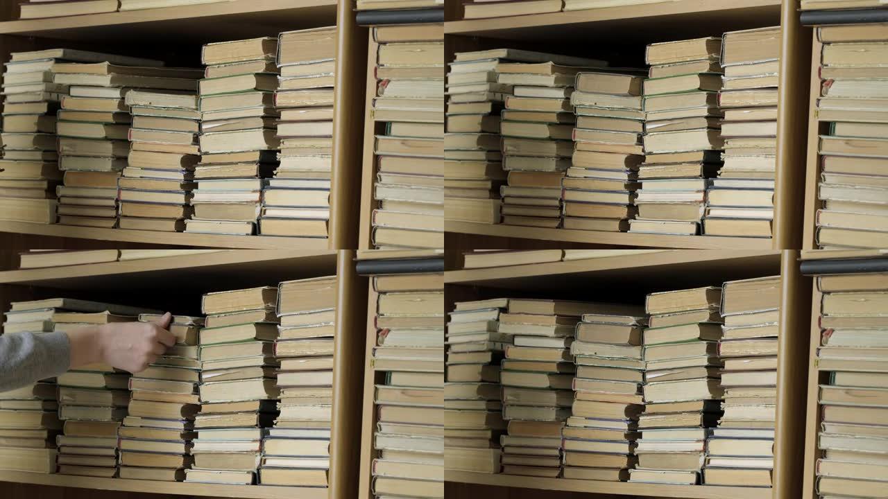 书架上的旧书。女人在图书馆的书架上寻找一本书。人类选择书籍。高加索人手触摸书架上的书。阅读和教育的概