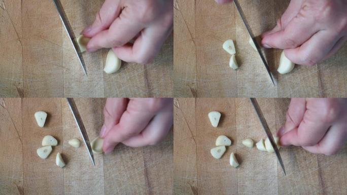 一瓣大蒜是由厨师在木砧板上切的。