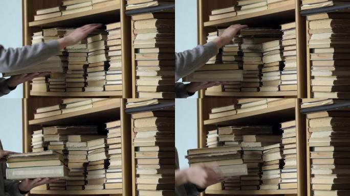 书架上的旧书。女人在图书馆的书架上寻找一本书。人类选择书籍。高加索人手触摸书架上的书。阅读和教育的概