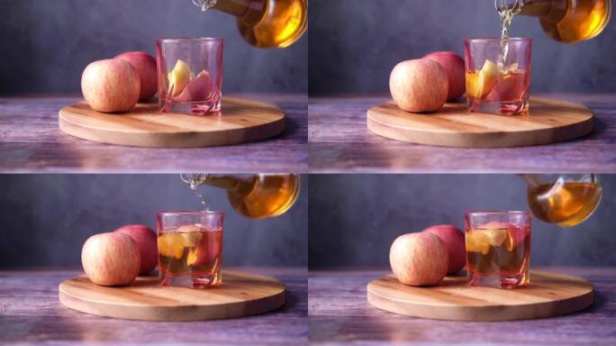 玻璃瓶中的苹果醋，桌上放着新鲜的青苹果