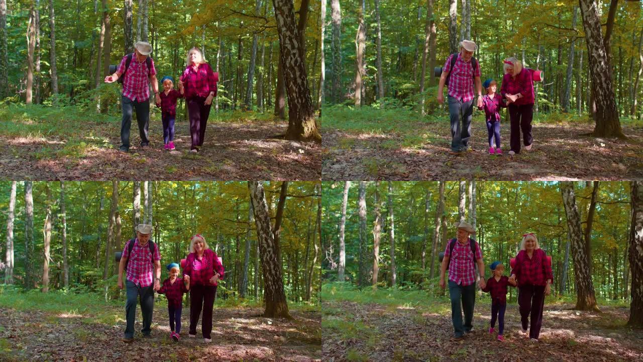 资深游客祖母，祖父，孙女孩子说话，背着木头背包走路