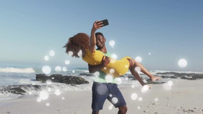 快乐的非裔美国人夫妇在海滩上使用智能手机在白色斑点上玩耍的动画
