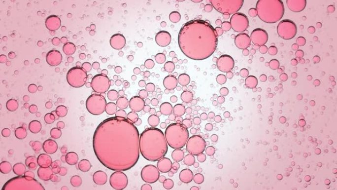 粉红色透明气泡在透明液体中自发移动