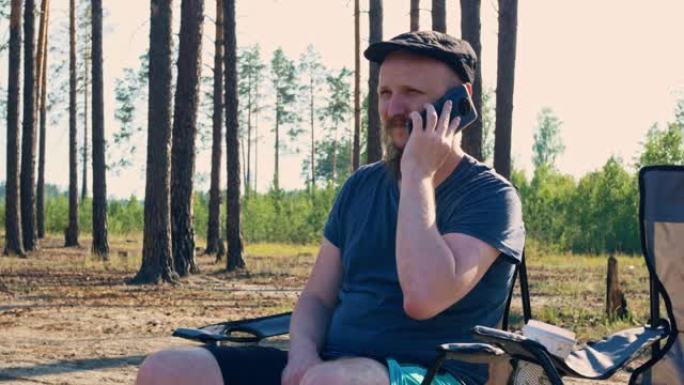 一个人在森林里度暑假，他正在和一个电话用户通话。天气很好。一家人在国家公园露营度假
