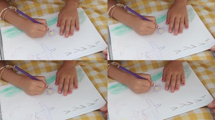 小女孩的手用彩色铅笔画画。