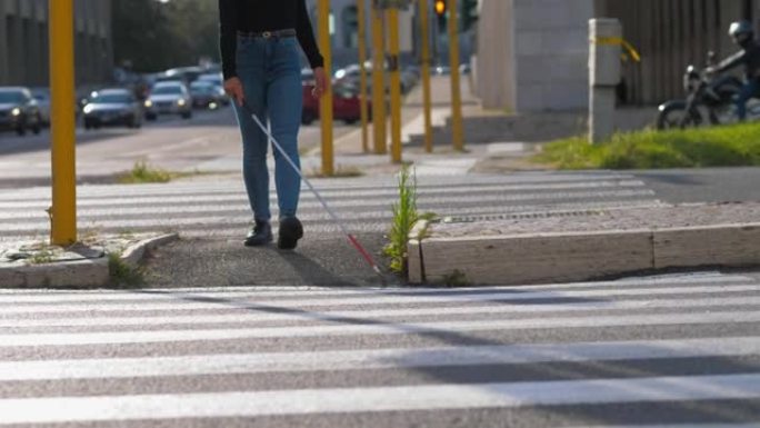 自给自足，独立-盲人妇女用拐杖过马路