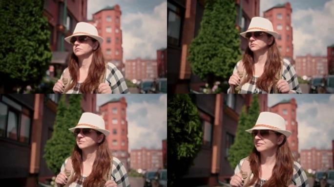 戴着帽子和墨镜的旅行者女人在街上行走的肖像，电影拍摄
