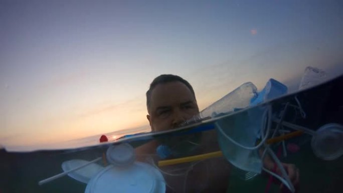 男子在被塑料污染的海洋中游泳