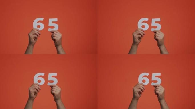 六十五号在手。显示数字的人，65岁，由雕刻纸制成，用于投票或数学学习