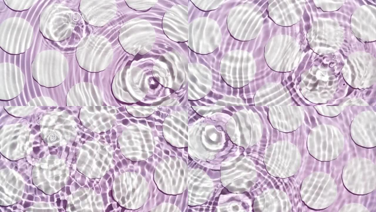 滴水落在紫色棉垫上的水圈中