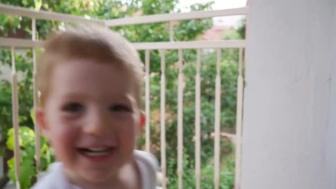 快乐可爱的男婴在家庭阳台上玩耍和跳舞