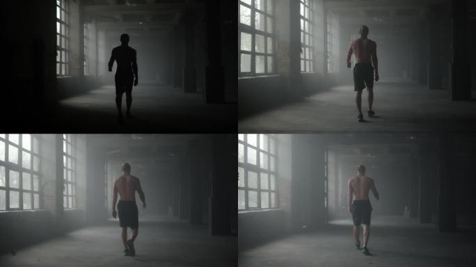 走在黑暗走廊上的男人剪影。锻炼后休息的运动员