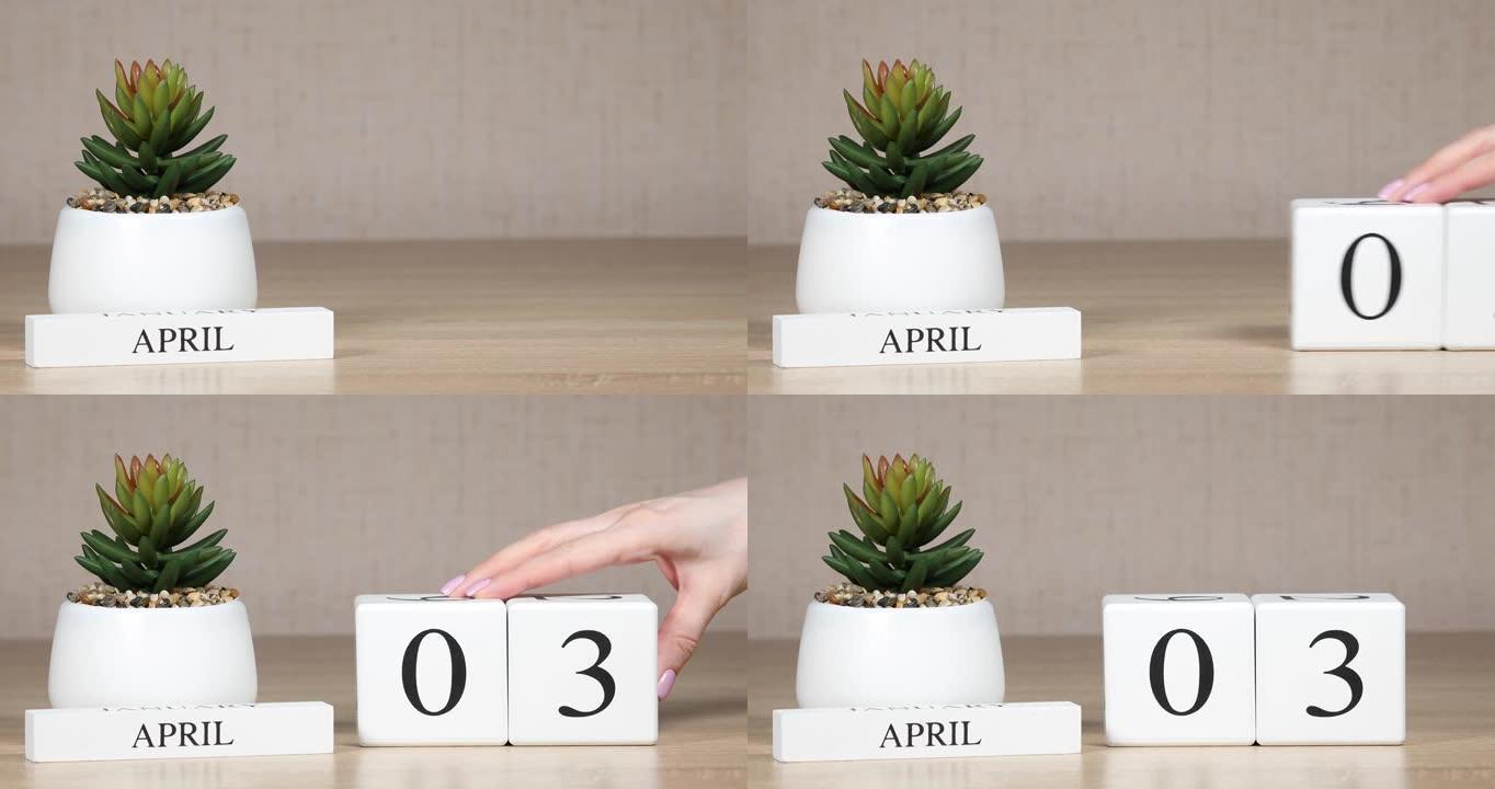 木制日历对4月3日来说是一个重要的事件，女人的手在日历上设置日期。春季。