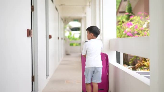 亚洲孩子在酒店提行李。旅游和度假的概念