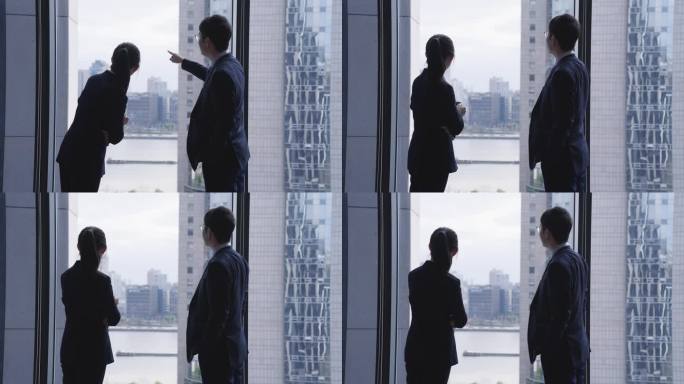 金融中心写字楼男女白领站在窗前向外看