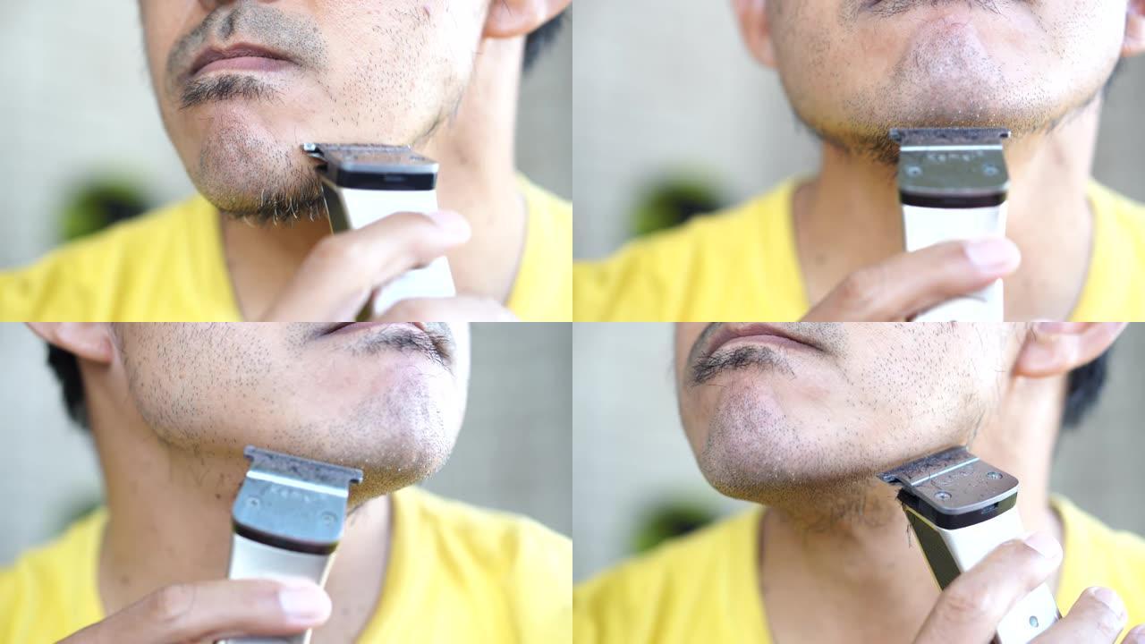 男人用电动剃须刀割胡子