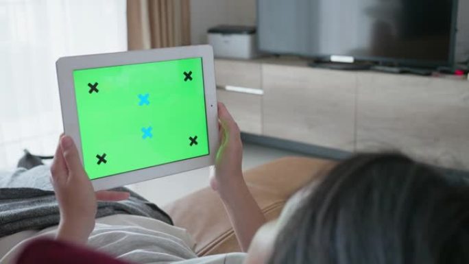 女人在绿屏上玩移动设备和平板电脑