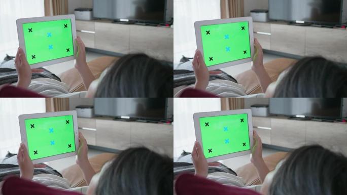 女人在绿屏上玩移动设备和平板电脑