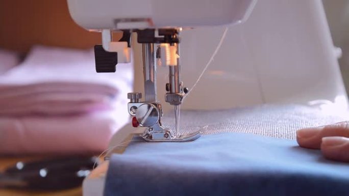 针扎织物的特写镜头，缝纫机的脚降低，缝纫过程。