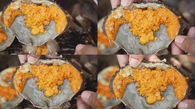 手拿鱼露腌蟹蛋、泰国鱼露腌蟹蛋放在托盘上