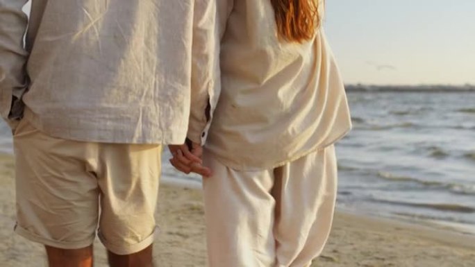 幸福的夫妇沿着夏日海滩散步