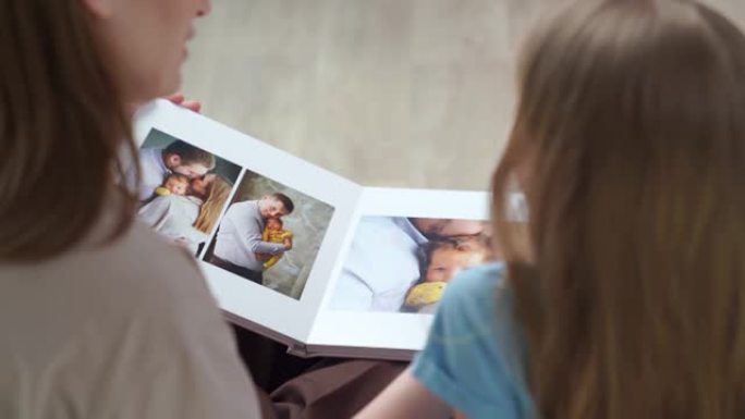 顶视图。母女看起来的书与家庭照片拍摄的照片