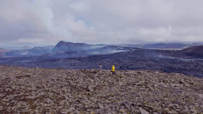旅行者站在远处山脉的岩石视野之上