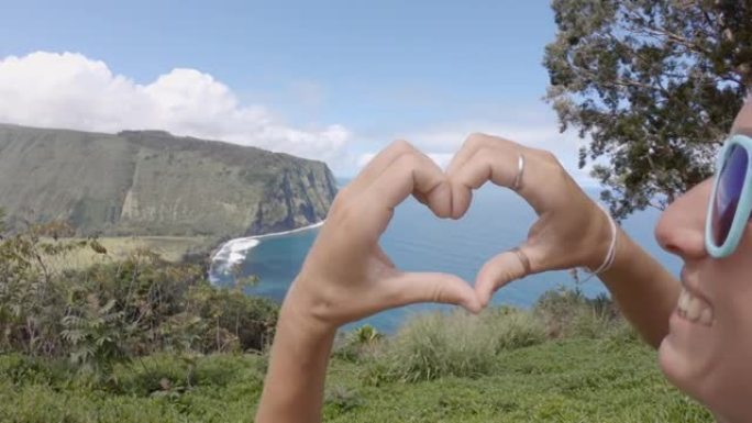 年轻女子在夏威夷的怀皮奥山谷了望台制作心形指框