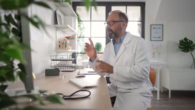 一位成熟的男性医生在办公室与患者进行视频通话