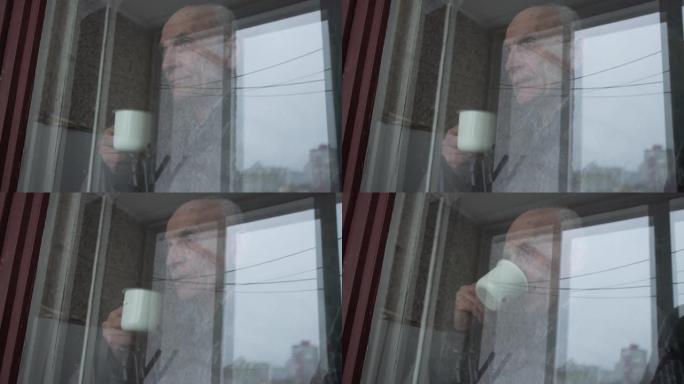 老人剪影看着大窗户外面，拿着杯子