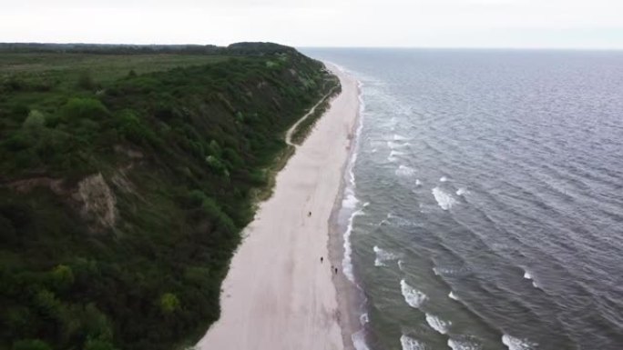 库里宁格勒在加里宁格勒吐痰的航拍镜头和恶劣大风天气下在海滩上散步的游客