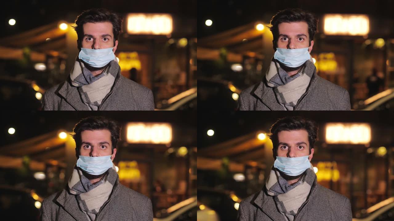 covid19-戴口罩的男子晚上不正确地盯着城市的摄像机