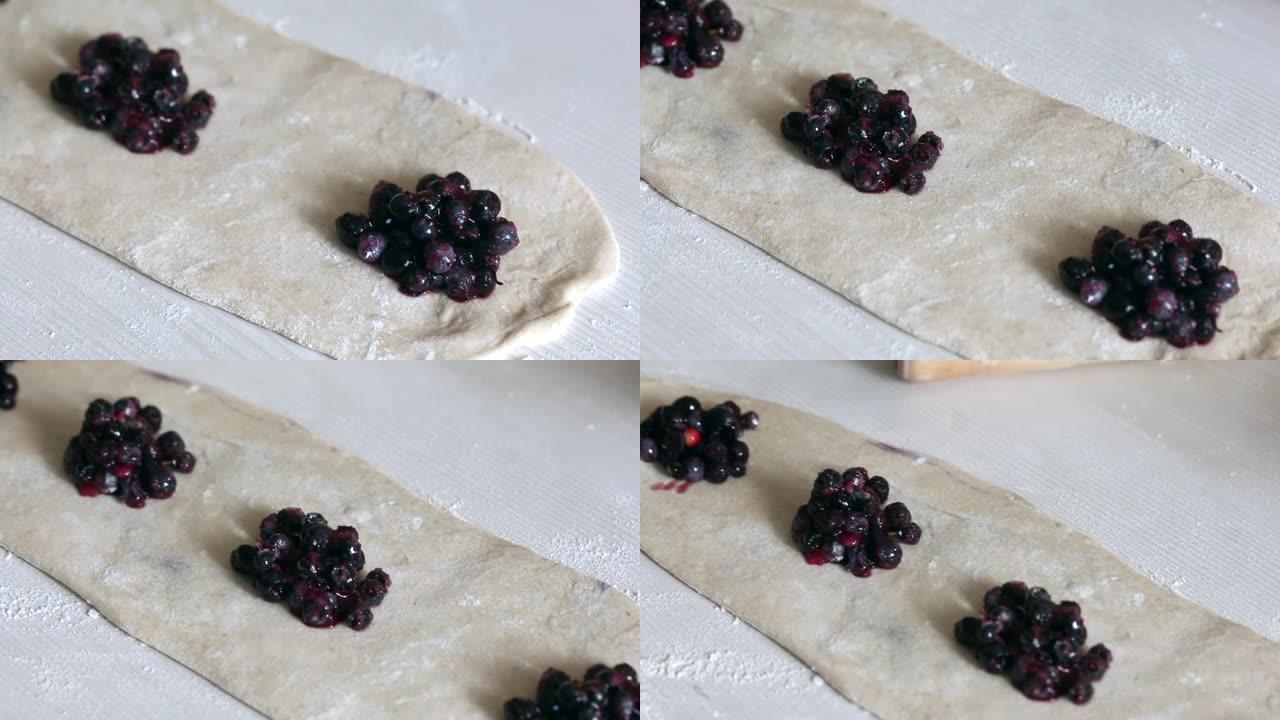 蓝莓铺在滚出的面团上。烹饪蓝莓饺子。特写镜头。