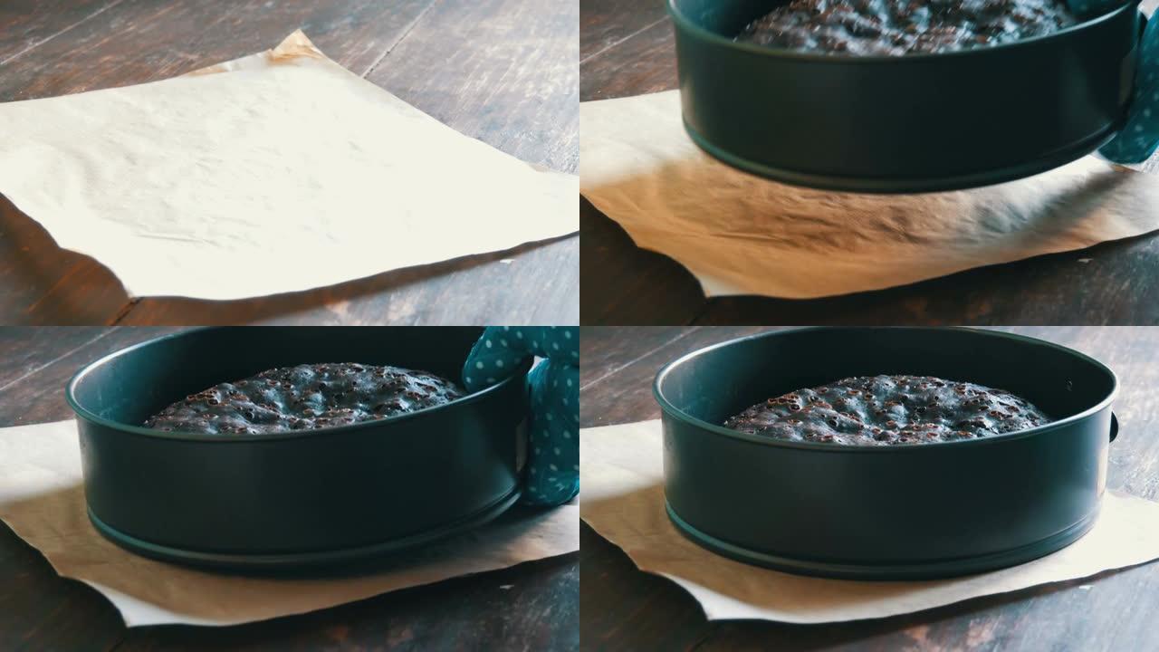 穿着蓝色厨房手套的女性手将新鲜出炉的自制巧克力布朗尼蛋糕放在桌子上