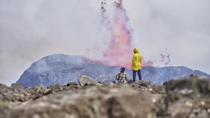 风景如画的游客欣赏火山爆发的风景