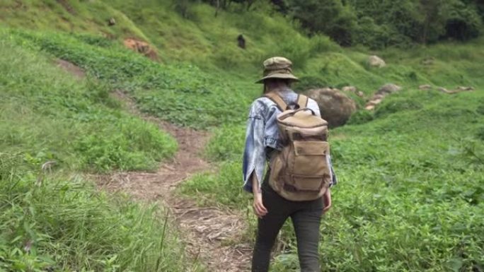 4k亚洲女性背包客在溪边的山路上徒步旅行