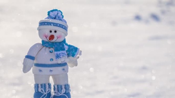 玩具搞笑雪人站在雪中在一个阳光明媚的冬日，下雪了。