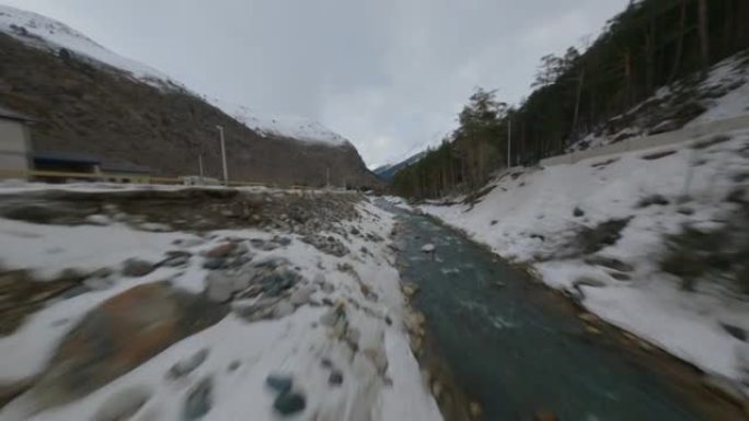 空中电影视角fpv运动无人机飞越自然岩石雪峰风景和狭窄河流