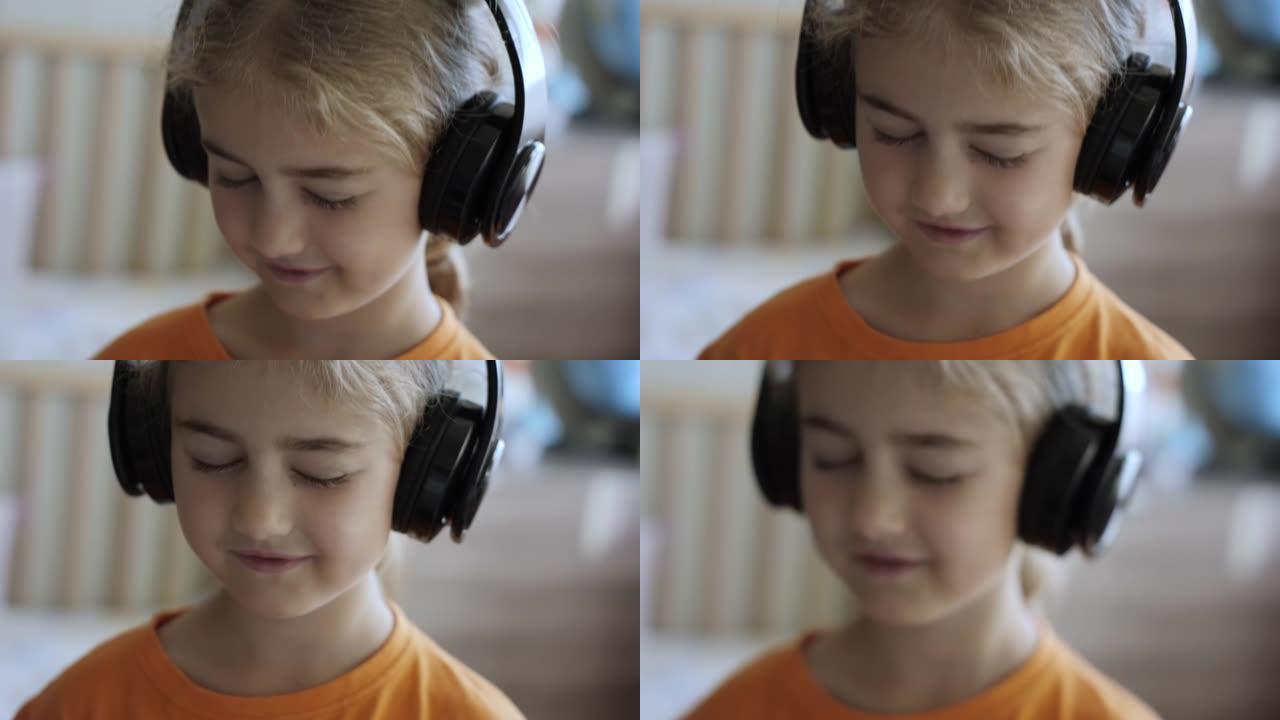 戴着耳机听音乐的可爱小女孩的肖像。孩子戴着耳机闭着眼睛放松时的慢动作。孩子在家听音乐。快乐无忧无虑的