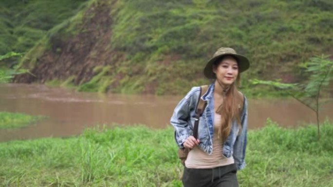 4k亚洲女性背包客在溪边的山路上徒步旅行
