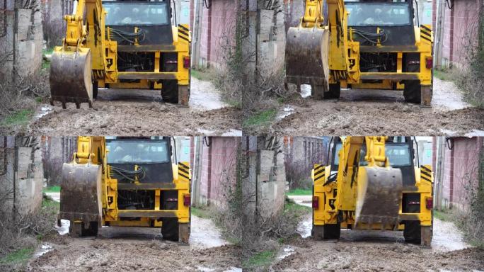 拖拉机在修复松动的碎石道路期间工作。挖掘机铲斗在路上，挖了一条沟。工程机械在项目上执行能源密集型重型