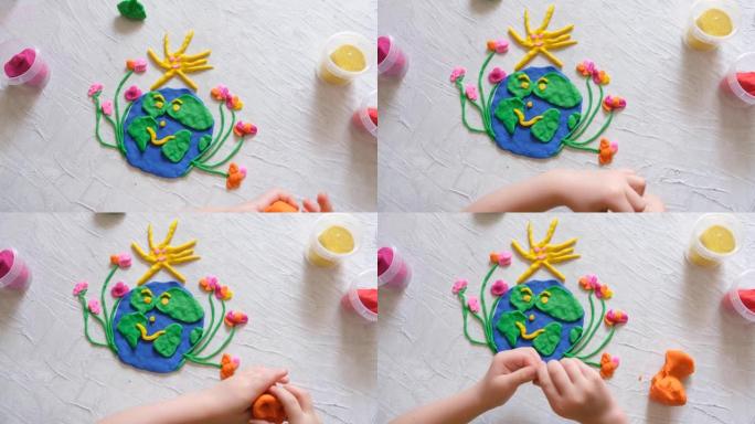 儿童为地球日雕刻橡皮泥行星。保护环境，拯救我们的星球。生态学概念。