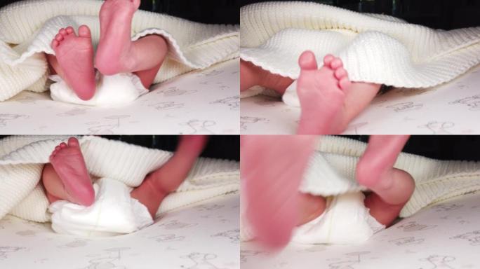 一个穿着尿布的小孩移动他的腿，新生婴儿