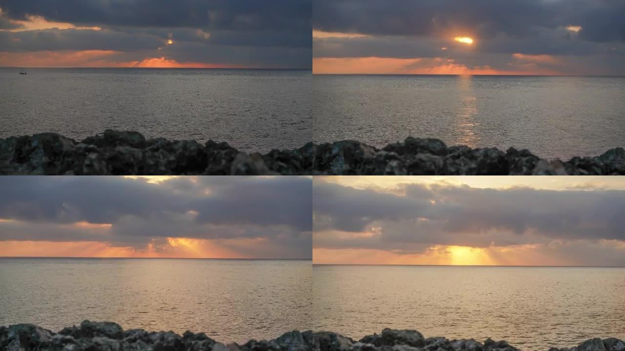 红色橙色的太阳升起在海面上，附近的岩石海岸，延时视频